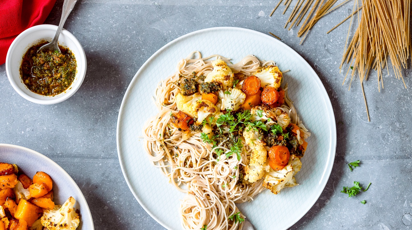 Macro close-up of golden seared chicken cutlets served over creamy sun-dried tomato orzo with fresh herbs
